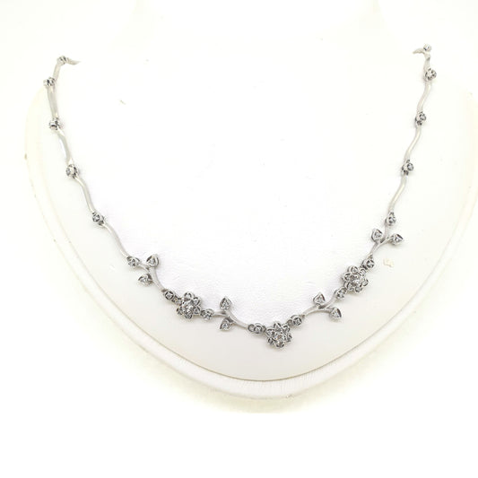A floral diamond necklace in 14ct white gold, on a neck bust, on a white background