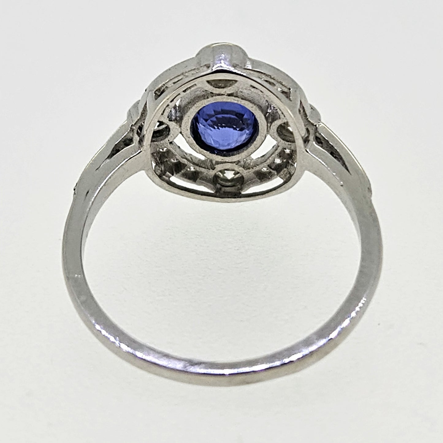An oval sapphire and round diamond open cluster ring in platinum
