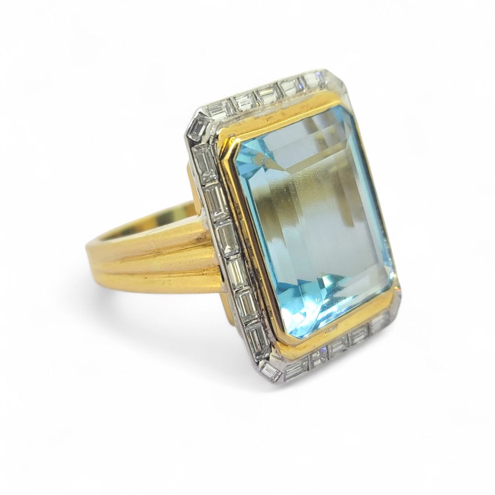 25ct Aquamarine and Baguette Diamond Cluster Ring, large 25cts emerald-shaped step-cut aquamarine bezel set in yellow gold with outer border of baguette-cut diamonds