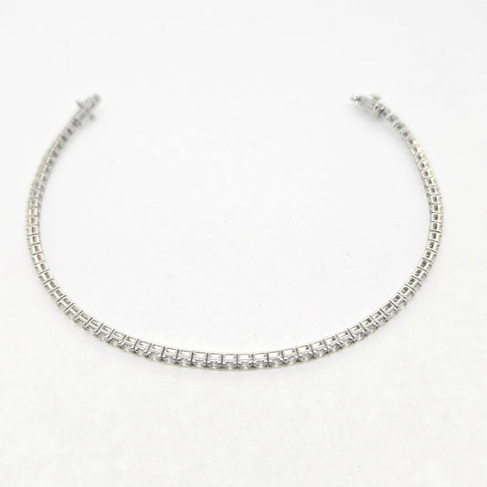 A brilliant cut diamond line bracelet, clasp open, on a white background