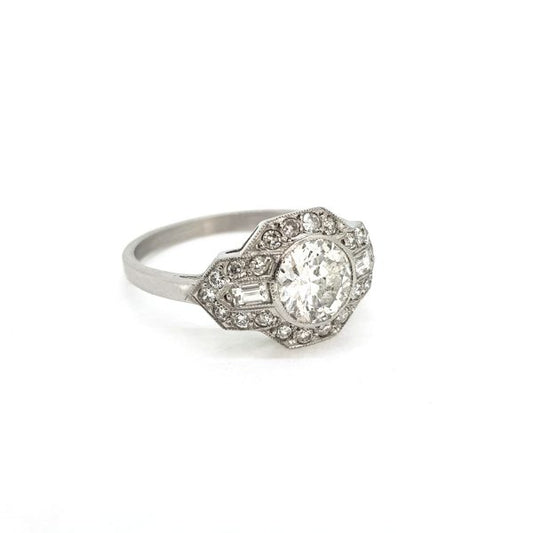 Art Deco Style Diamond Cluster Ring; 0.92 carat diamond has a geometric diamond-set surround accented with baguette cut diamond shoulders, in 18ct white gold