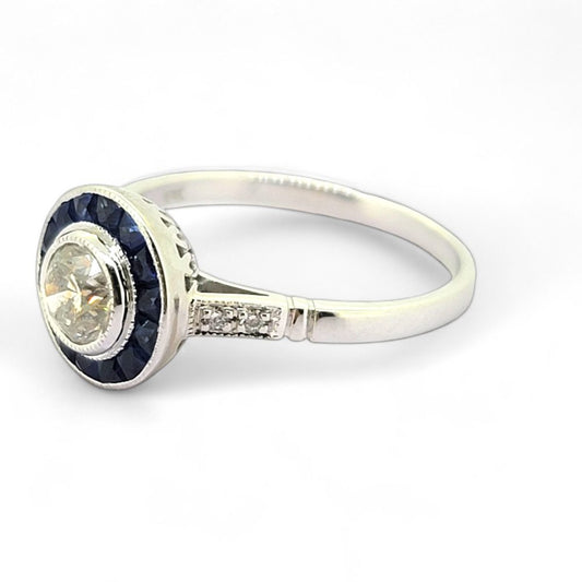0.53ct Diamond and Sapphire Target Engagement Ring, 0.53ct round brilliant-cut diamonds surrounded by a halo of calibre sapphires in 18ct white gold