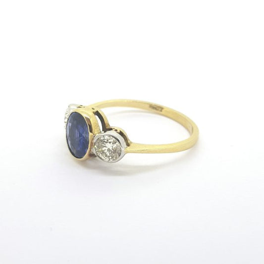 Sapphire and Diamond Three Stone Ring; featuring a 1.26 carat oval faceted sapphire flanked by 0.67cts brilliant cut diamonds, in 18ct yellow gold