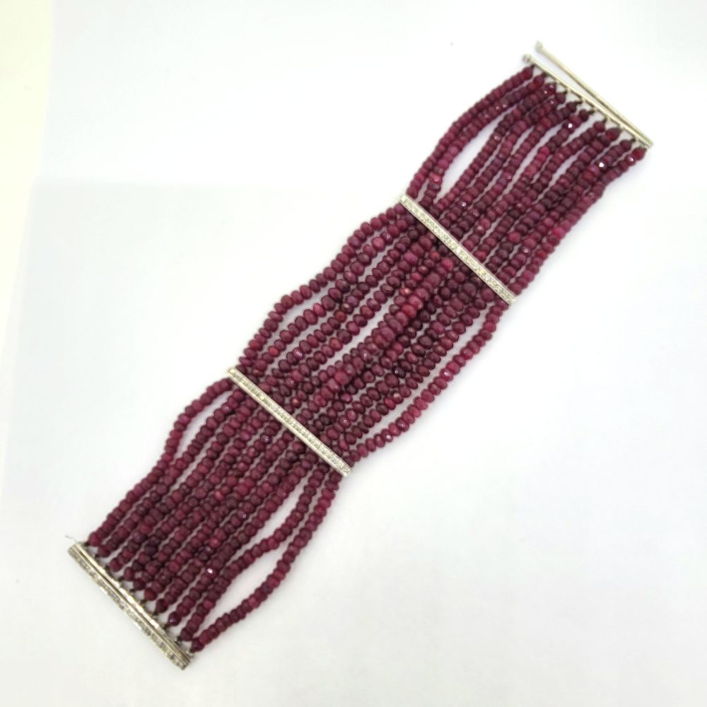 Multi Strand Ruby Bead and Diamond Bracelet, 150 carats, wide bracelet composed of ten strands of ruby beads secured with sections of diamond-set white gold bars