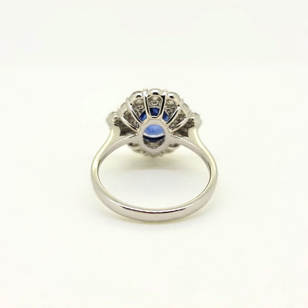 An oval sapphire, brilliant cut and baguette cut diamond cluster ring in white gold