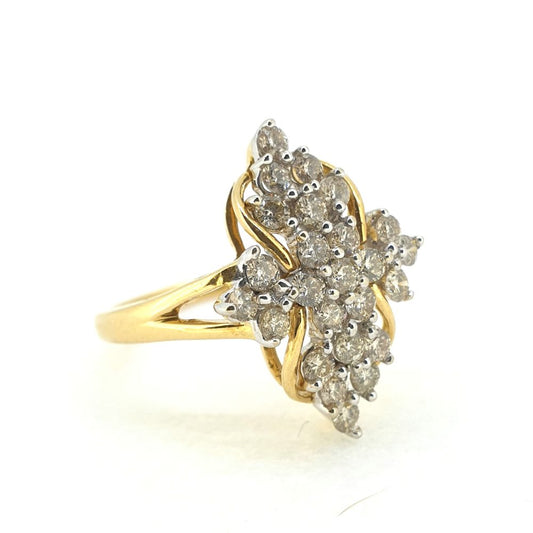 A fancy shaped diamond cluster ring in yellow and white gold, against a white background