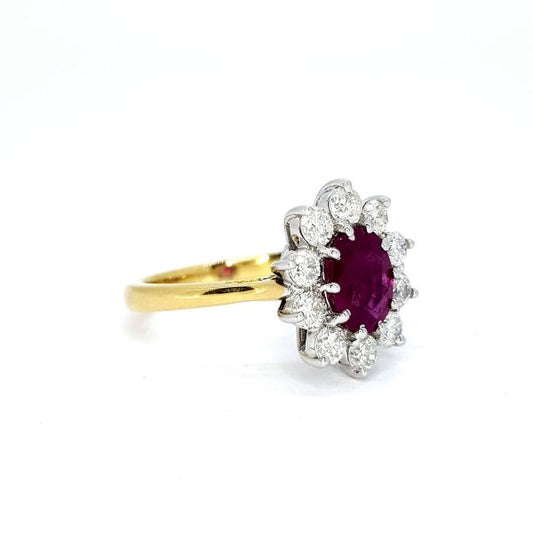 Ruby and Diamond Cluster Ring; central oval faceted ruby surrounded by ten brilliant-cut diamonds, claw set in 18ct white gold, mounted to plain 18ct yellow gold shank