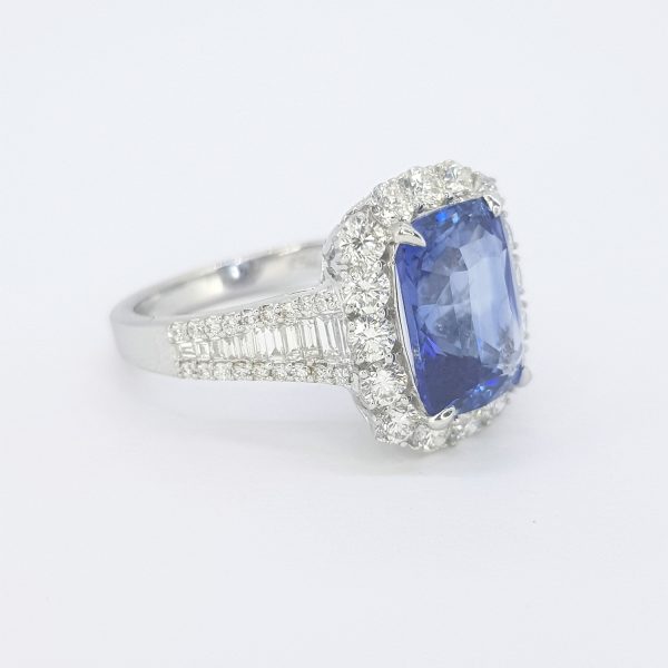 Sapphire and Diamond Cluster Dress Ring; central 5.07ct rectangular sapphire set within a border of brilliant cut diamonds, with baguette and brilliant-cut diamond set shoulders, in 18ct white gold