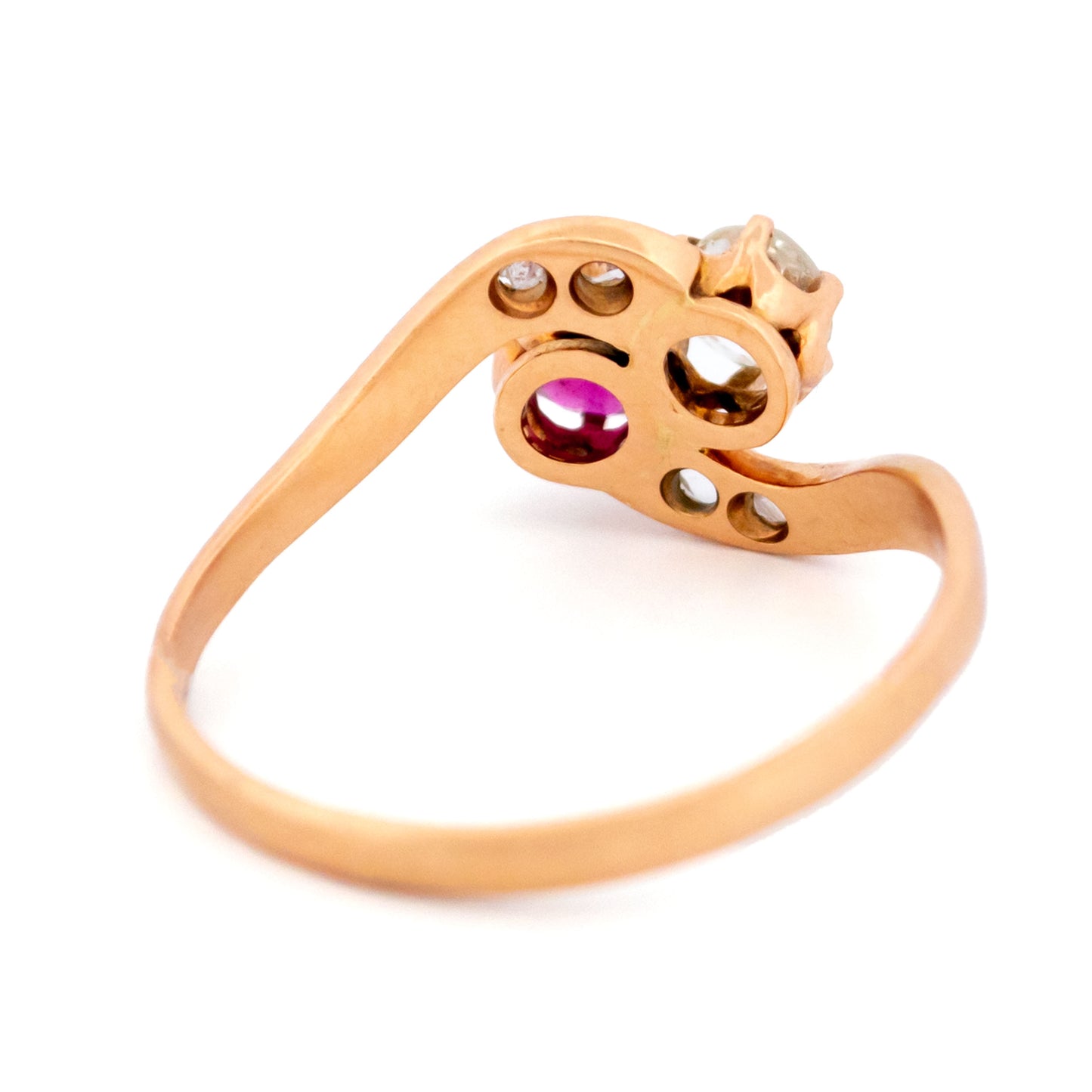 A two stone crossover ring in yellow gold with a ruby and diamonds