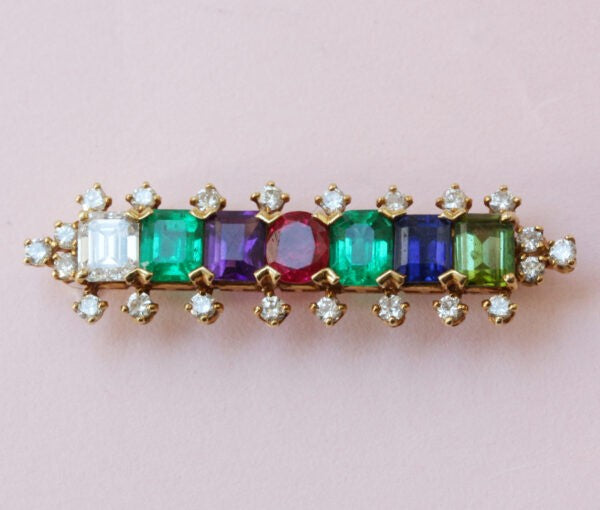 Julius Cohen DEAREST bar brooch in 18ct Yellow Gold; comprising of Diamond, Emerald, Amethyst, Ruby, Emerald, Sapphire and Tourmaline, Signed