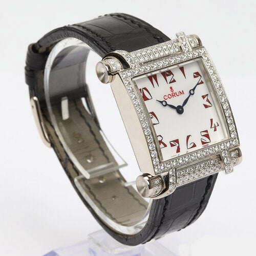 Corum Tabogan 18ct White Gold Watch; 18ct white gold case encrusted with diamonds, white dial with red Arabic numerals, Quartz movement, on Corum black leather strap with 18ct white gold buckle