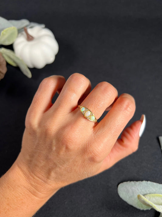 A boat-shaped gold ring with opals and diamonds, modelled on a hand