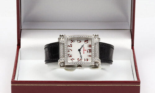 Corum Tabogan 18ct White Gold Watch; 18ct white gold case encrusted with diamonds, white dial with red Arabic numerals, Quartz movement, on Corum black leather strap with 18ct white gold buckle