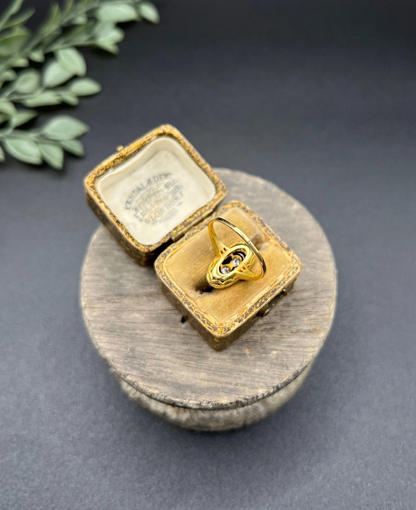 An oval cluster ring with diamonds and sapphires in platinum and yellow gold, in an antique ring box
