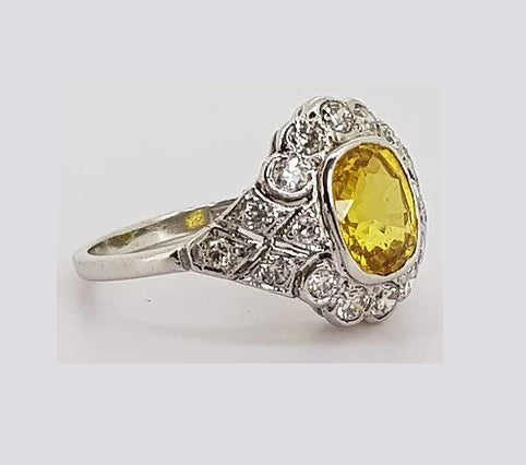 Yellow Sapphire and Diamond Cocktail Ring; 2.10 carat oval-cut yellow sapphire surrounded by 065cts diamonds, set into an intricate 18ct white gold mount.