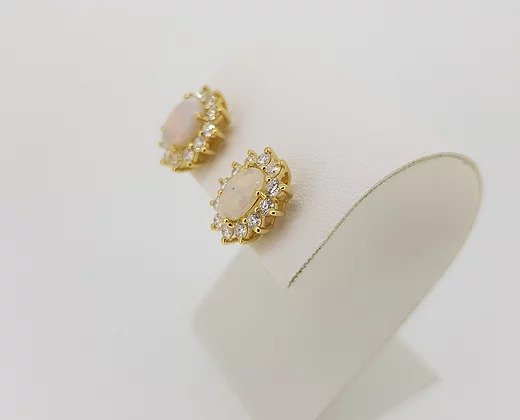 Opal and Diamond Oval Cluster Stud Earrings; 2.34cts oval cabochon opals surrounded by 1.06cts brilliant-cut diamonds, in 18ct yellow gold