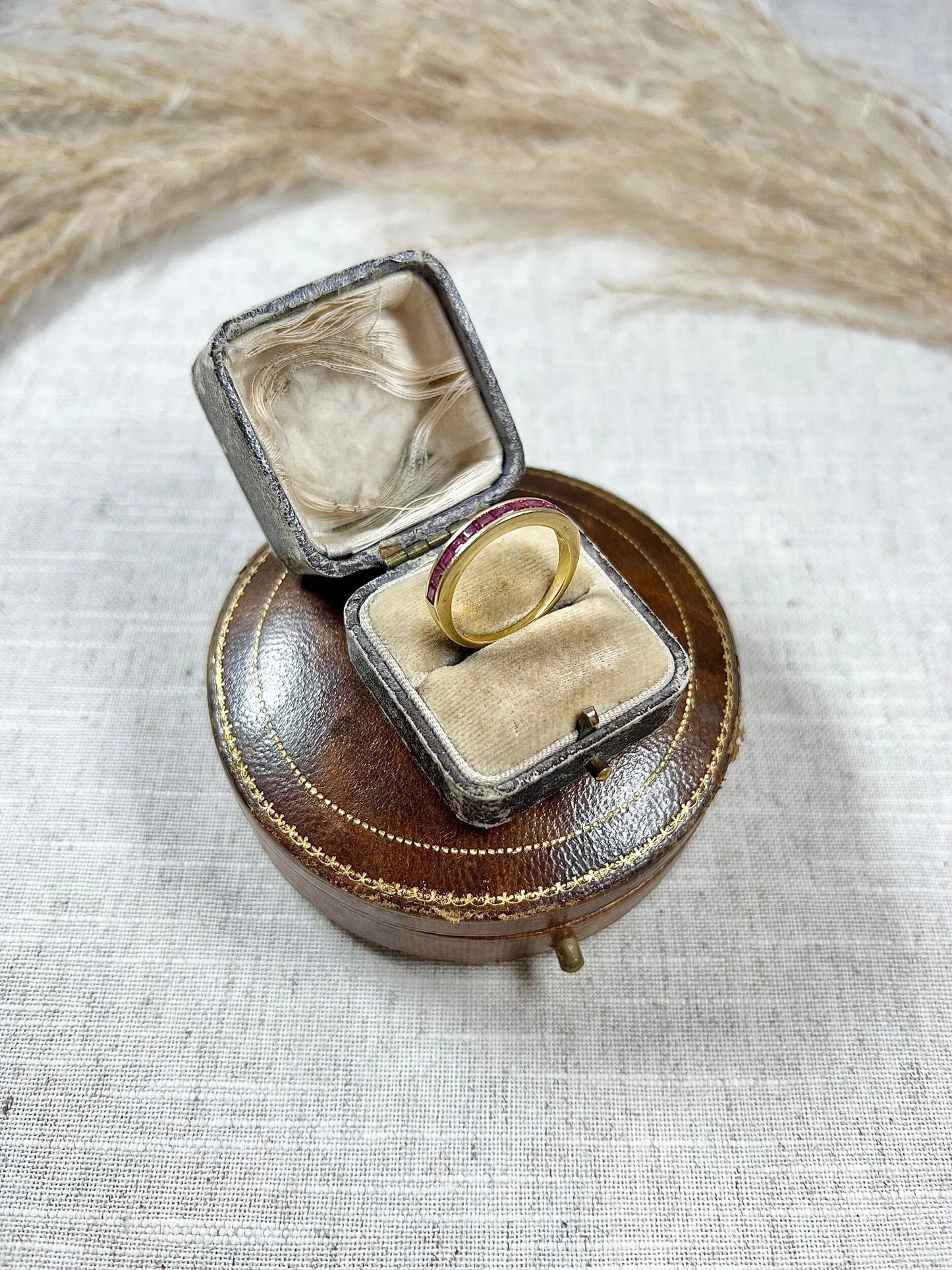 A yellow gold ruby channel set eternity band, in an antique ring box