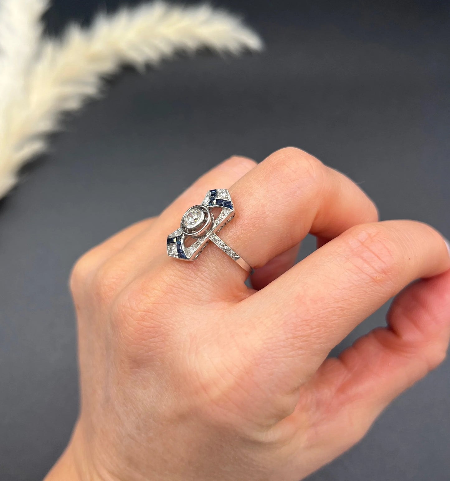 An Art Deco design sapphire and diamond ring in white gold, modelled on a hand