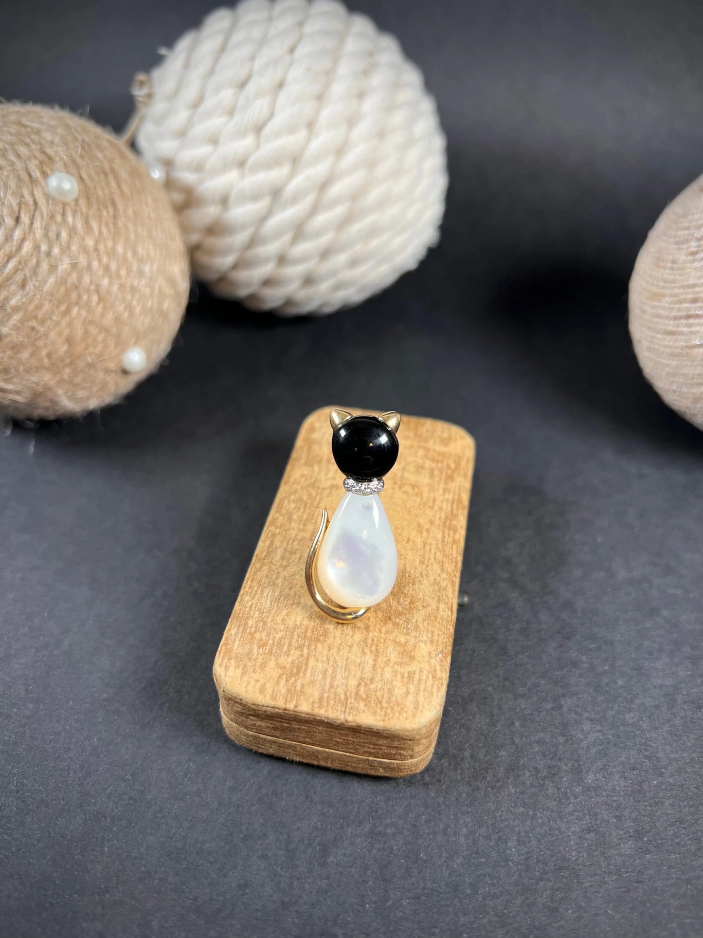 A cat-shaped brooch in yellow gold with black onyx, mother of pearl and a diamond set collar