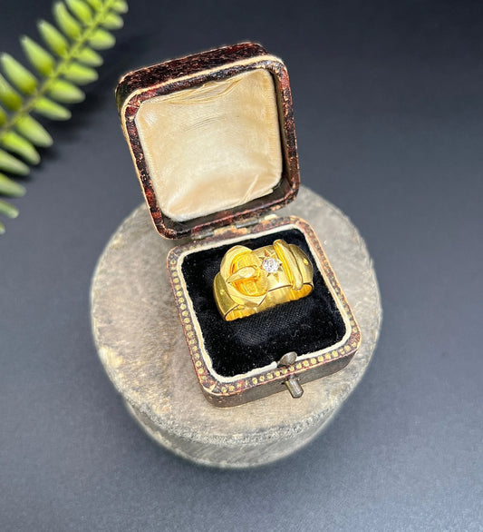A yellow gold diamond set buckle ring, in a ring box
