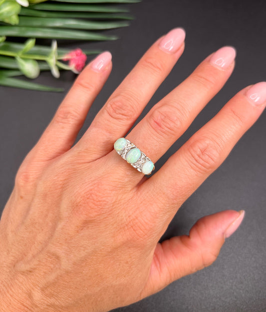 A yellow gold and platinum ring set with opals and diamonds, modelled on a hand