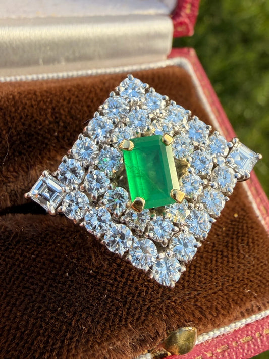 An emerald and diamond square shaped cluster ring in whte gold, in a ring box