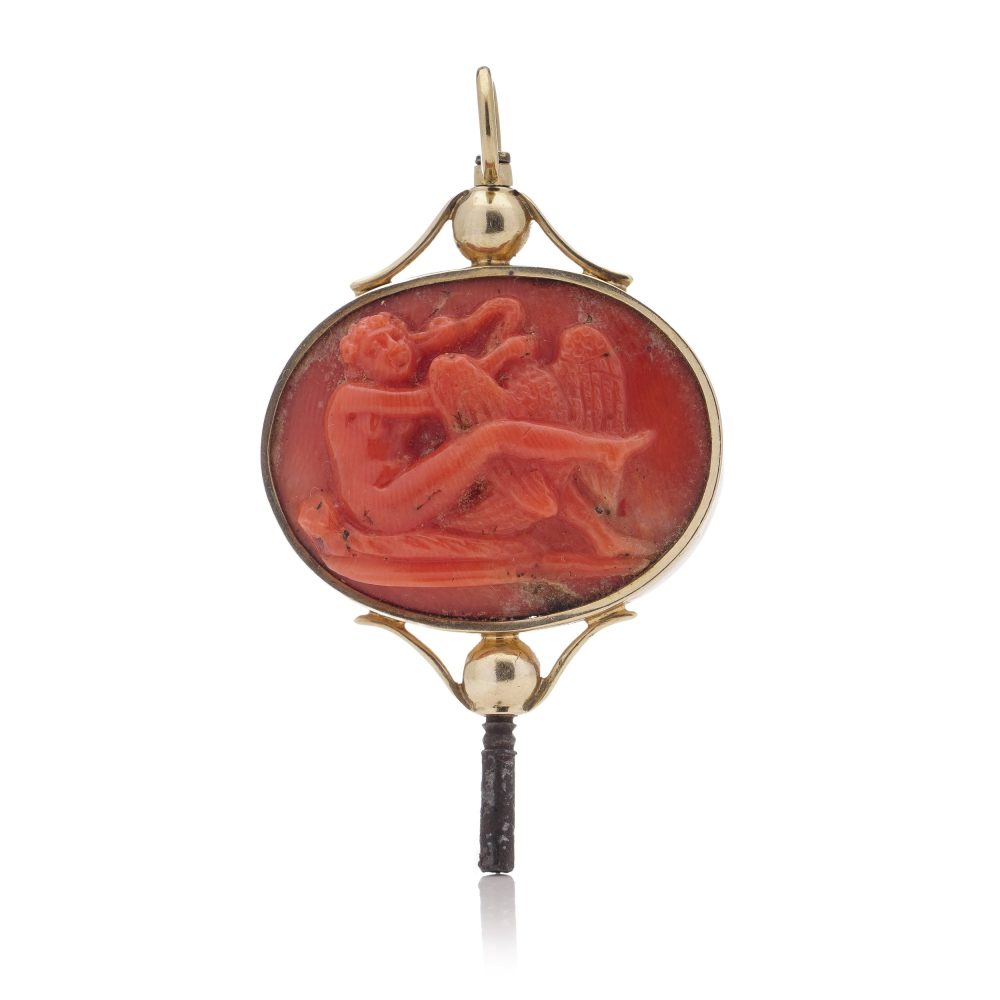 Victorian pocket watch key/pendant in gold and carved coral showing neoclassical scenes.