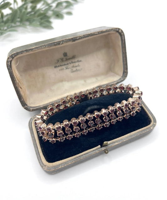 A triple row garnet bracelet in rose gold, in an antique box