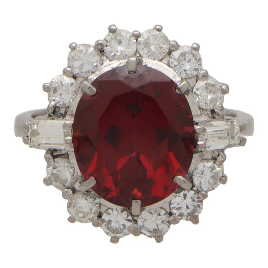 Garnet and diamond halo ring set in platinum.