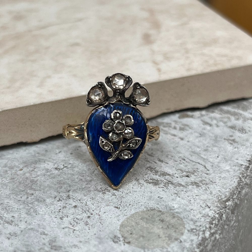 Antique late Victorian ring with blue enamel and diamond flower design.