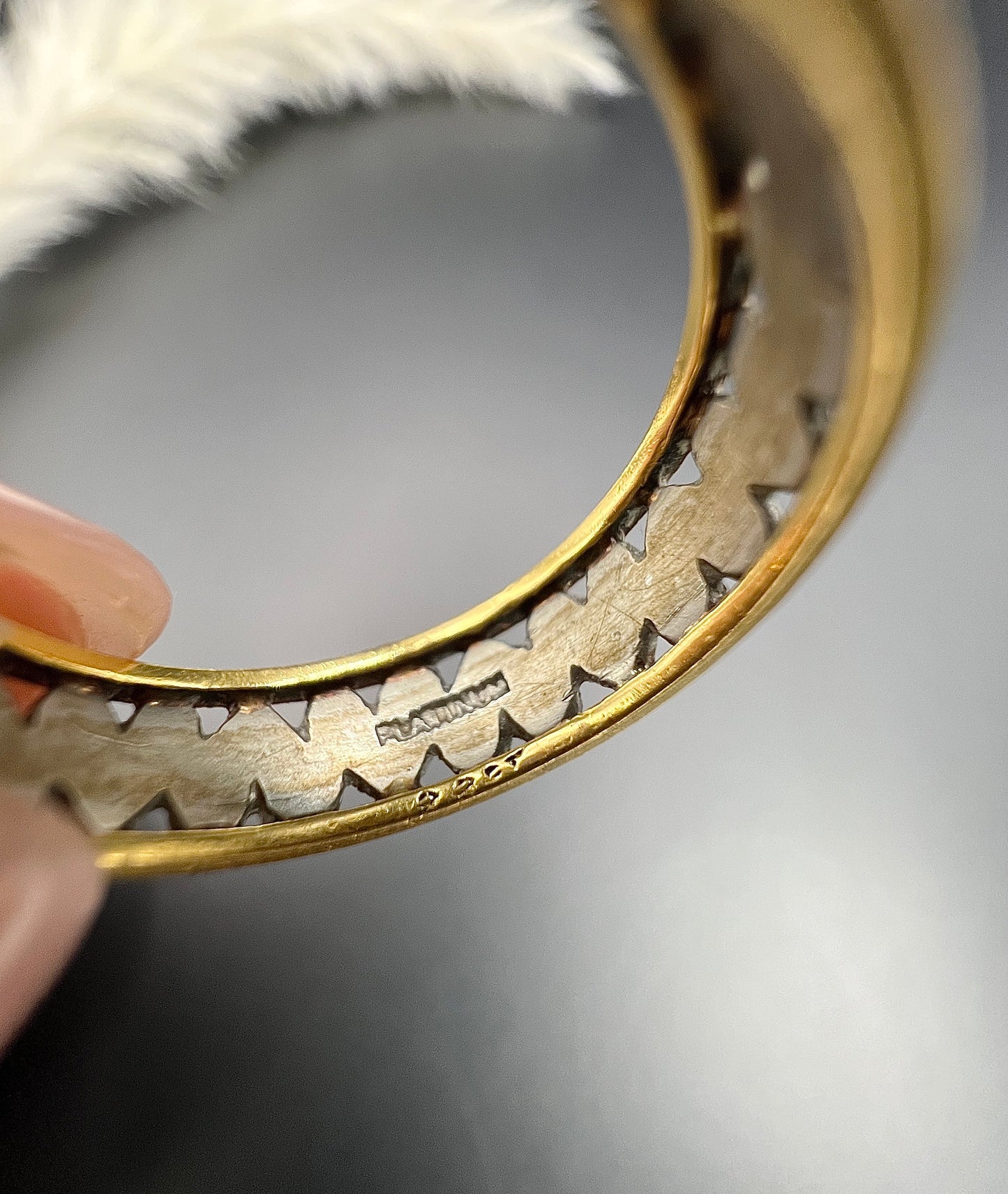 Close-up of PLATINUM and 22CT stamps on a ring