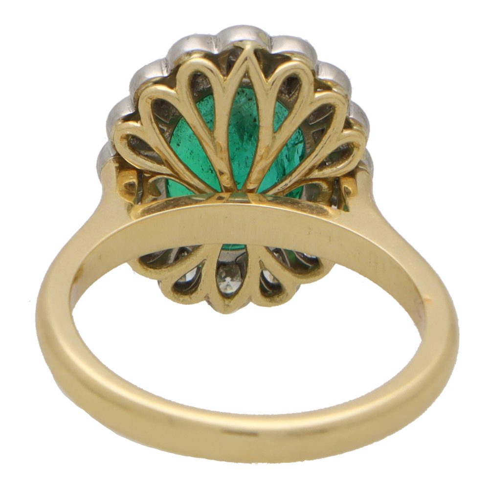 Emerald and diamond cluster ring in gold and platinum.