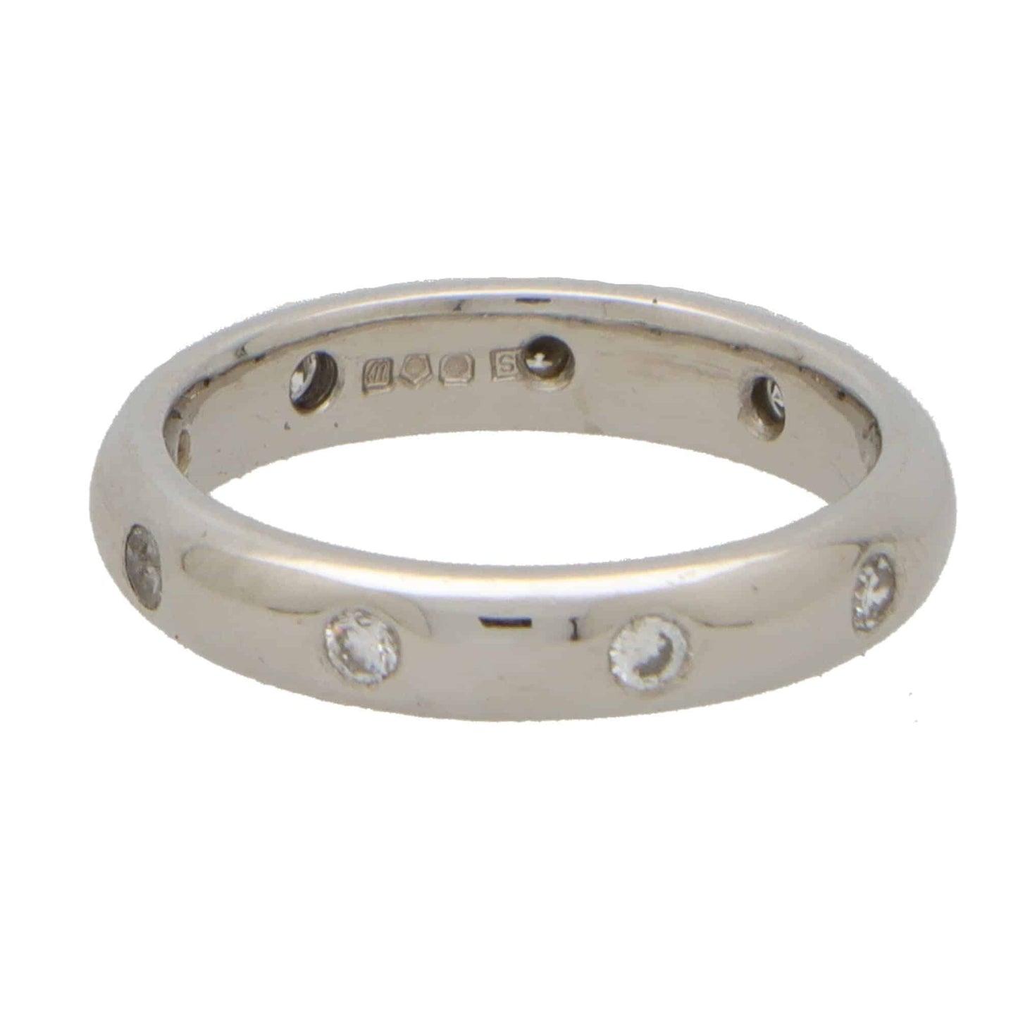 A platinum band ring with round damonds, on a white background