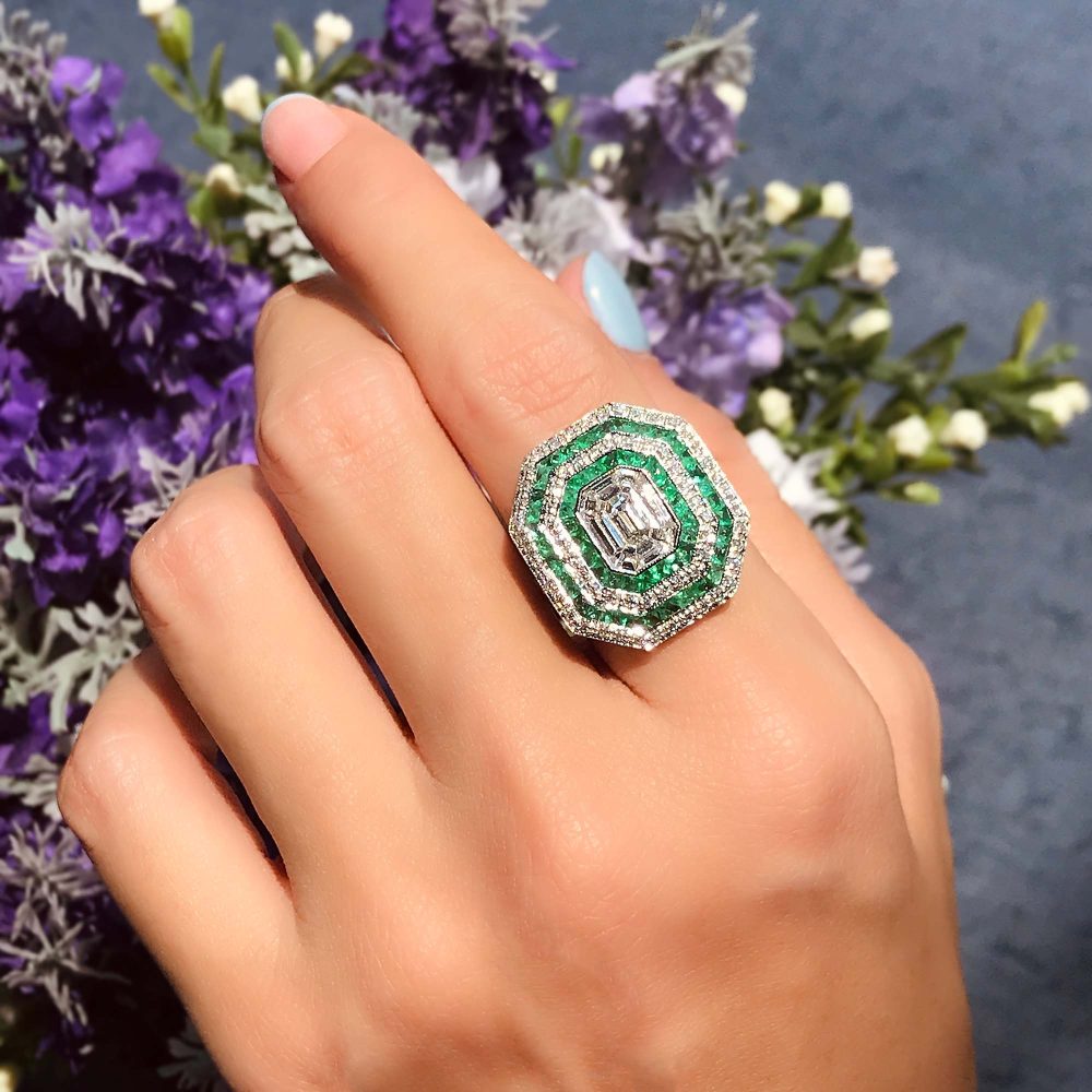 Art Deco Style Illusion Set Emerald Cut Diamond and Emerald Cluster Ring, multiple diamonds together form emerald shape centre framed by four rows of French cut emeralds and shimmering diamonds in 18ct white gold
