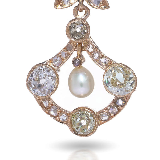 A pearl and old cut diamond drop earring with leaf motifs in yellow gold, on a white background