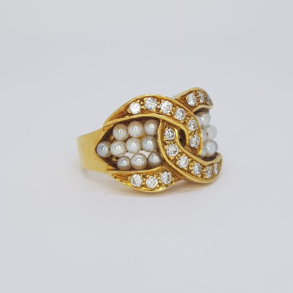 Pearl and Diamond Crossover Ring; diamond set outer crossover border encompasses three rows of pearls, in 18ct yellow gold.