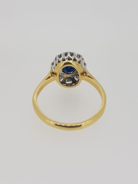 Vintage Sapphire and Diamond Cluster Ring; central oval sapphire within a diamond surround, in 18ct gold, Circa 1970s