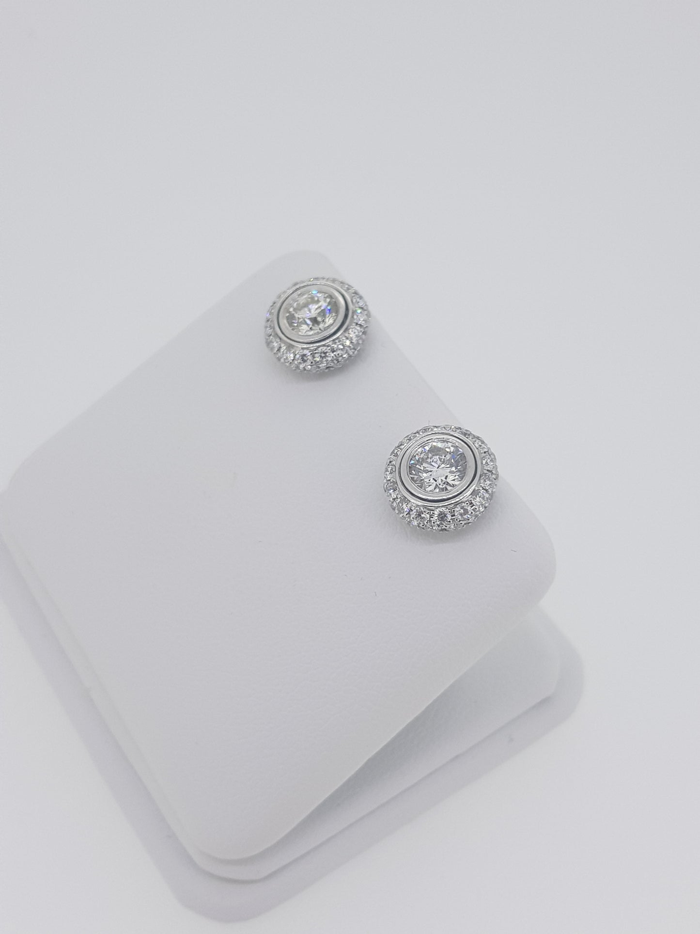 A pair of diamond round cluster earrings in white gold