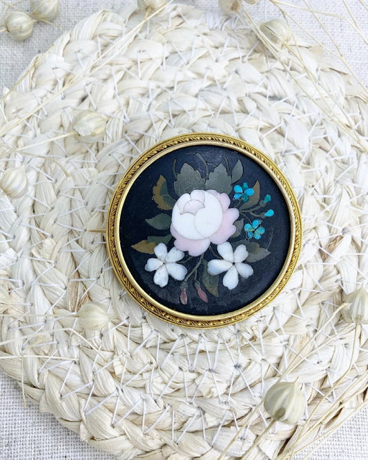 A circular pietra dura flower brooch mounted in yellow gold