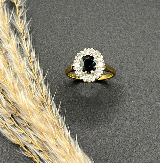 A sapphire and diamond oval cluster ring in gold