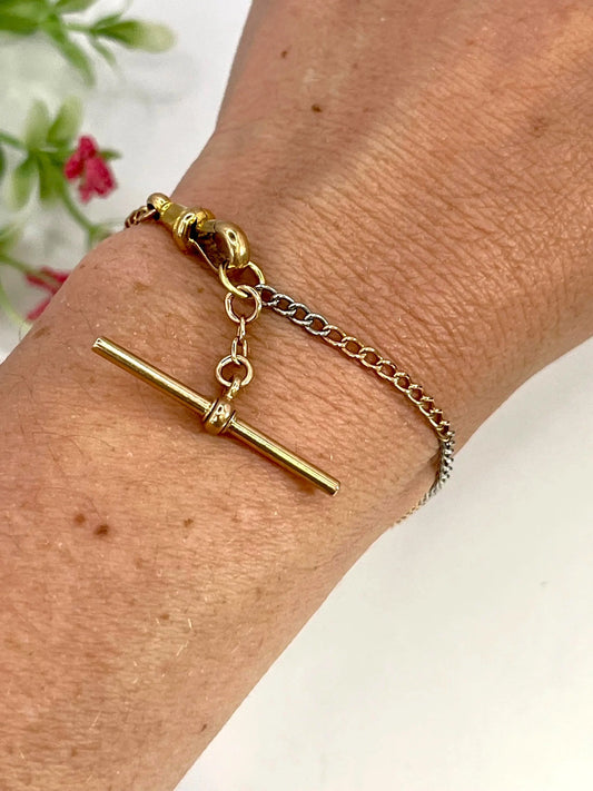 A curb link bracelet in gold and platinum with a T-bar and lobster clasp modelled on a wrist