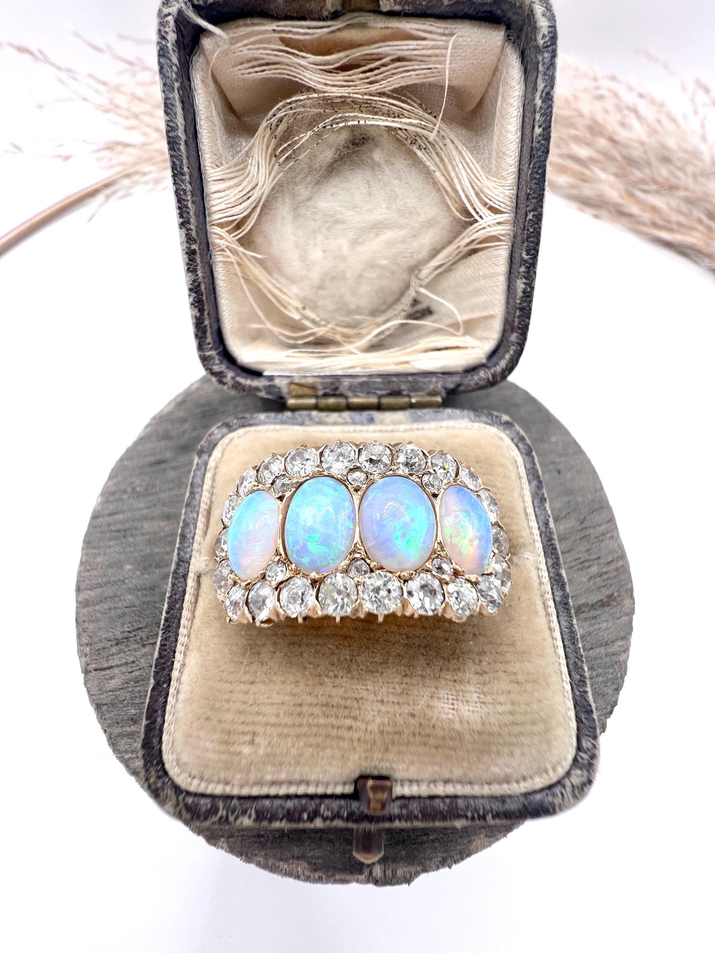 An antique oval opal and old cut diamond cluster row ring in yellow gold, in a ring box