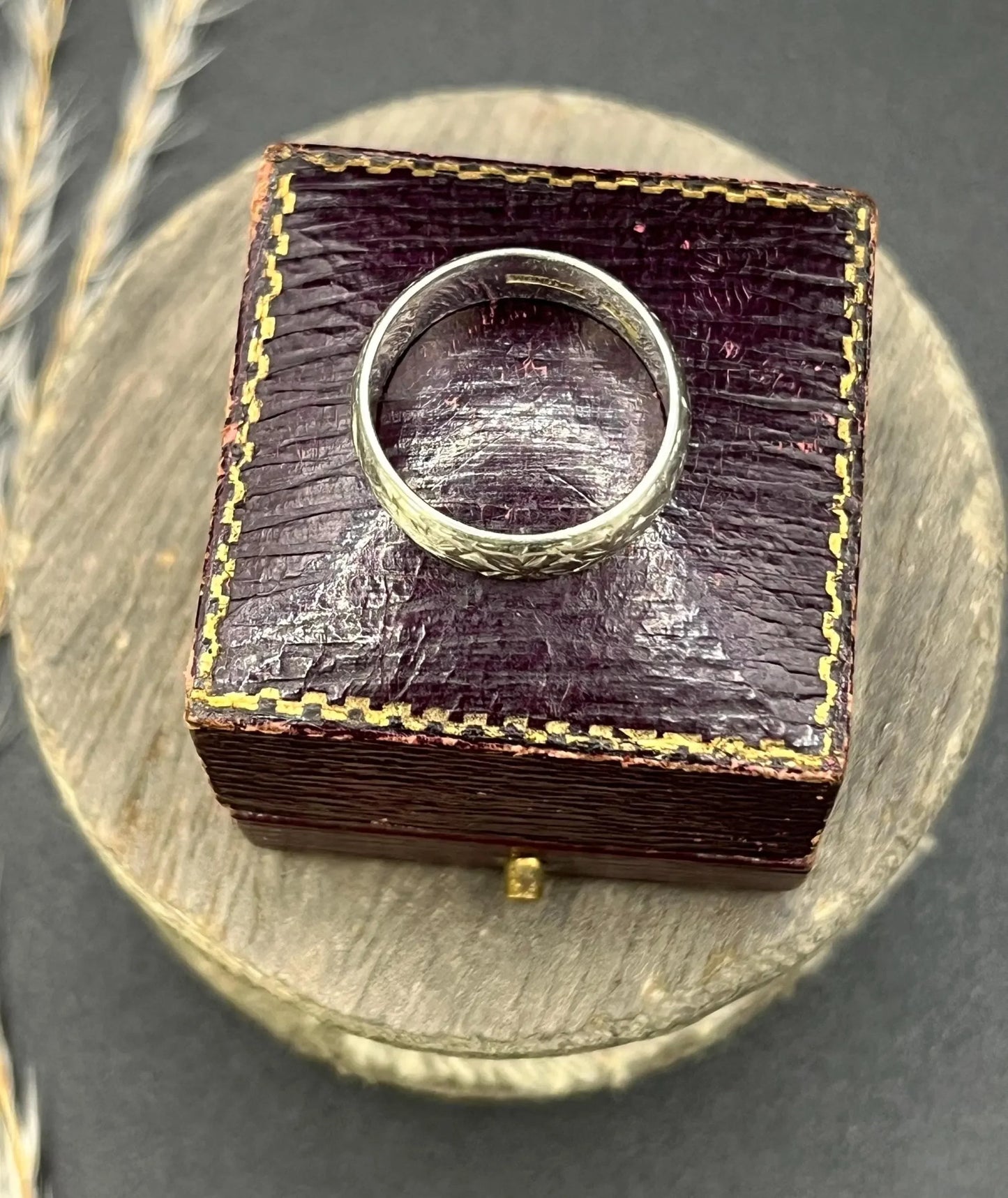 An engraved platinum wedding band ring, in an antique ring box