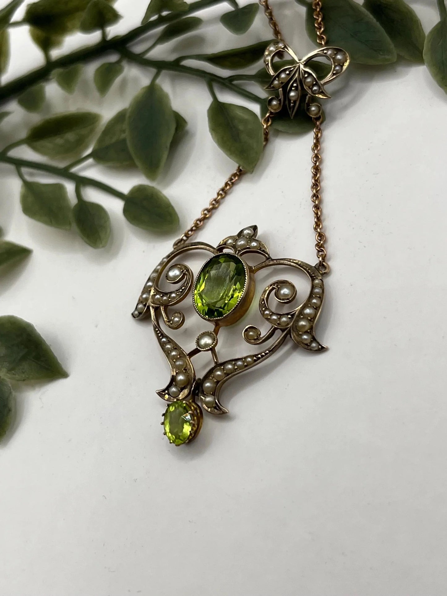 A yellow gold peridot and seed pearl pendant necklace