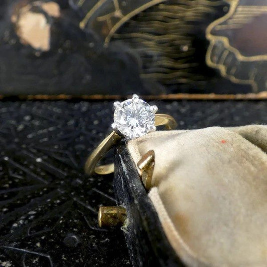 Diamond solitaire ring in yellow and white gold.