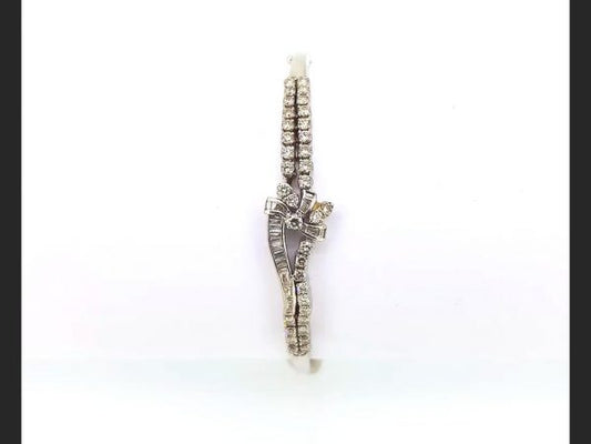 Diamond Bangle; Double row of round cut diamonds and baguette cut diamonds culminating in a delicate bow design, set in 18ct white gold