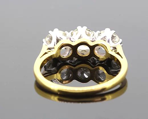Three Stone Diamond Ring; A classic diamond trilogy ring featuring three round brilliant-cut diamonds totaling 2.06 carats, claw-set, 18ct yellow gold band.