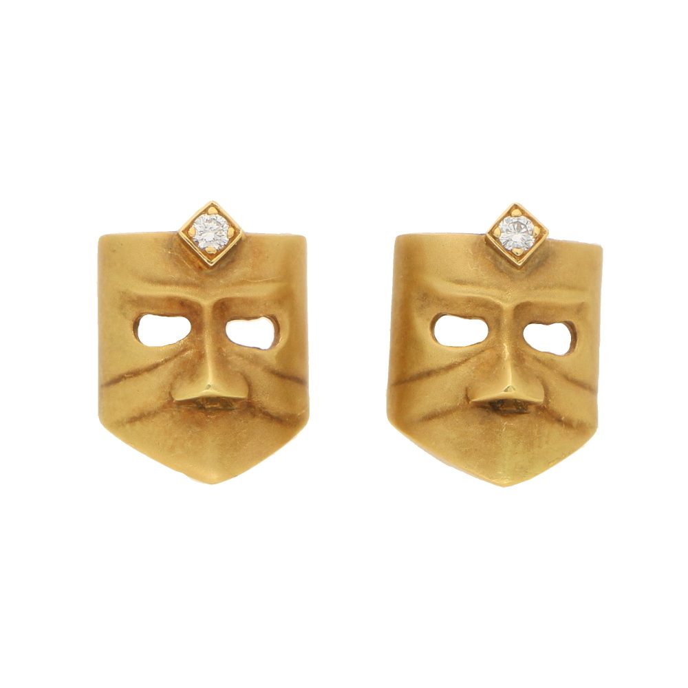 A pair of diamond masque stud earrings in gold.