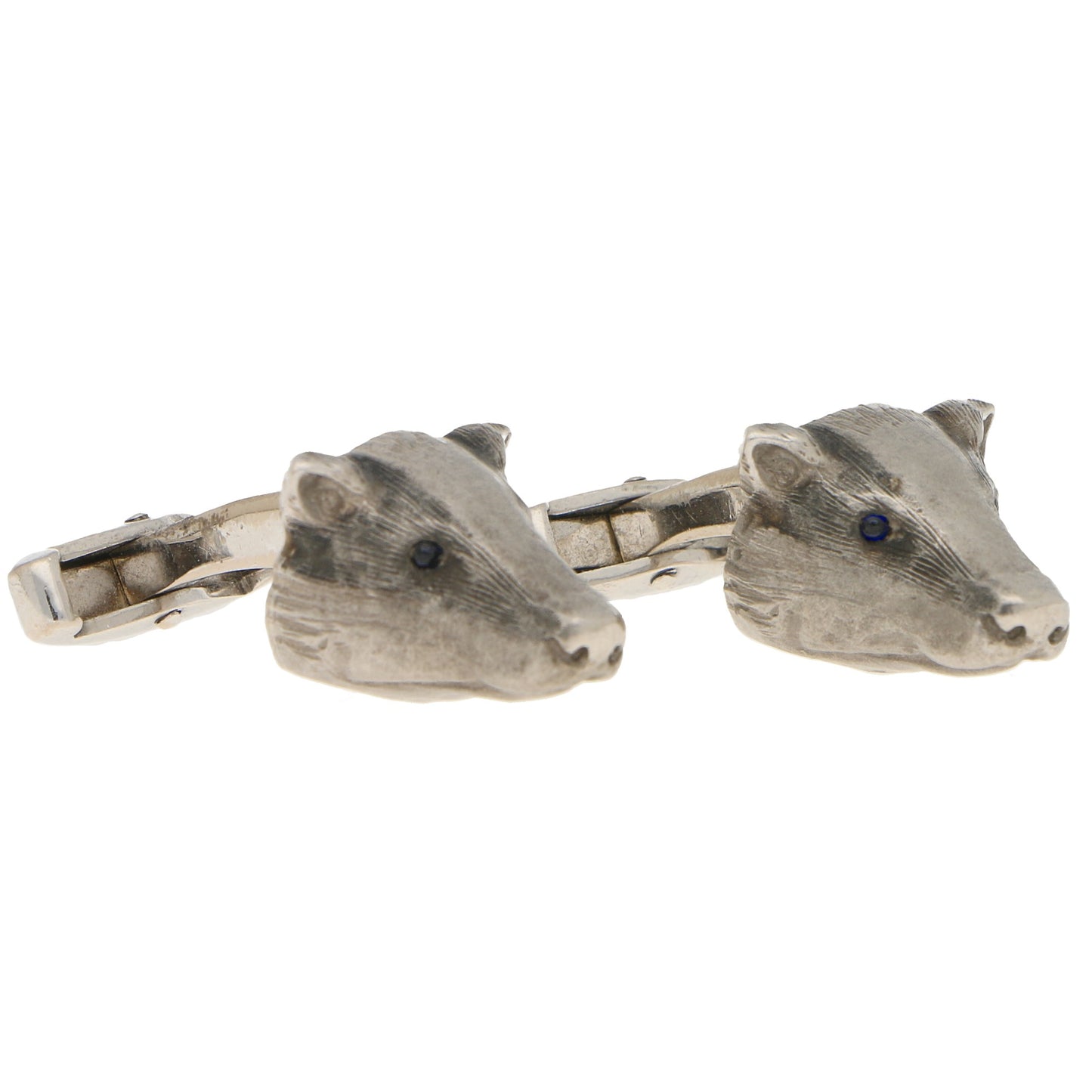A pair of white gold badger head cufflinks with sapphire eyes, on a white background