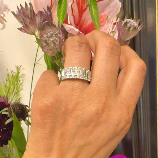 A baguette cut and brilliant cut diamond band ring in white gold, modelled on a hand